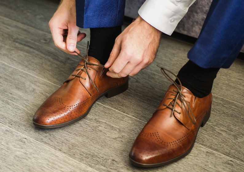 Man tying his brown dress shoes