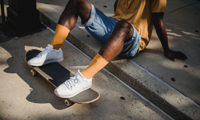 A man with white shoes on a skateboard